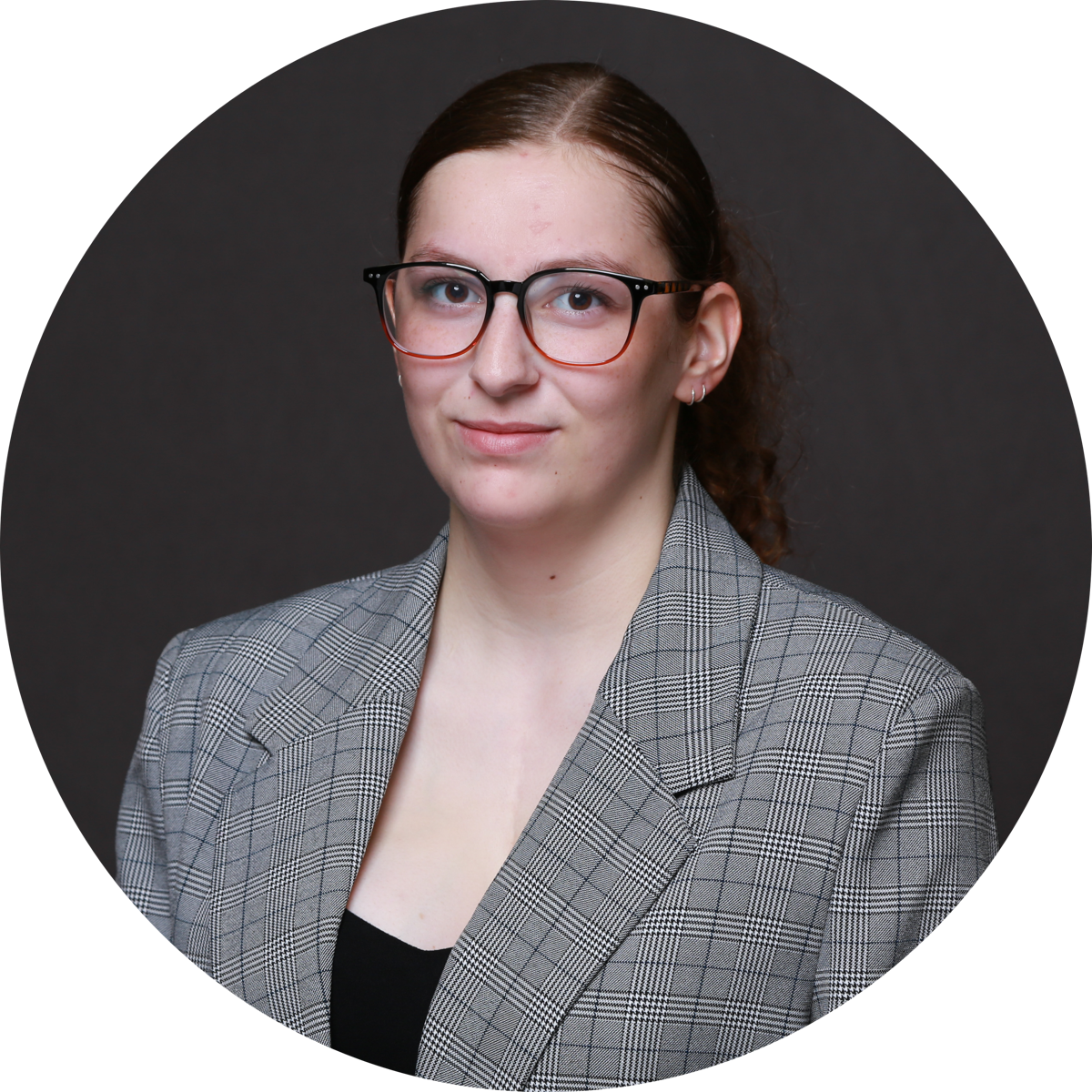 Sophia's headshot. She has brown eyes, brown hair, and glasses.